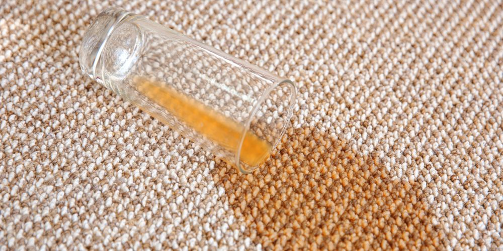 spilled orange juice on a beige carpet